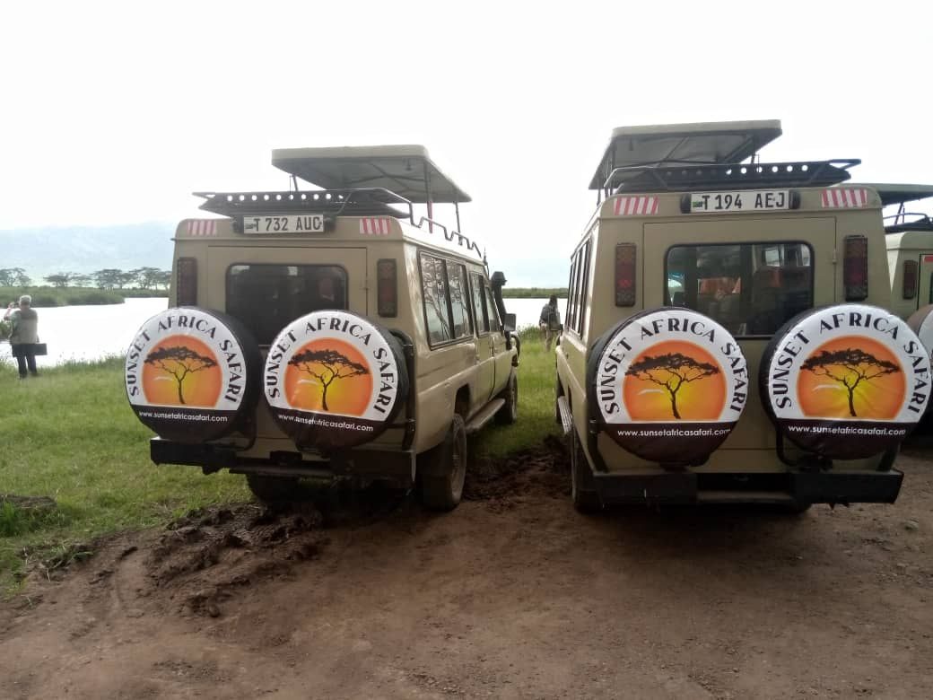 Two Sunset Africa Safari Land Cruisers with the company logo on the spare wheels