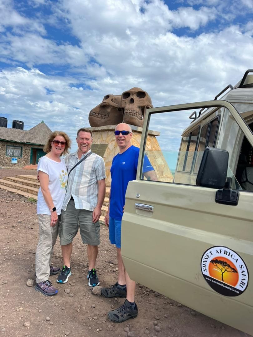 Travellers standing beside a Sunset Africa Safari vehicle